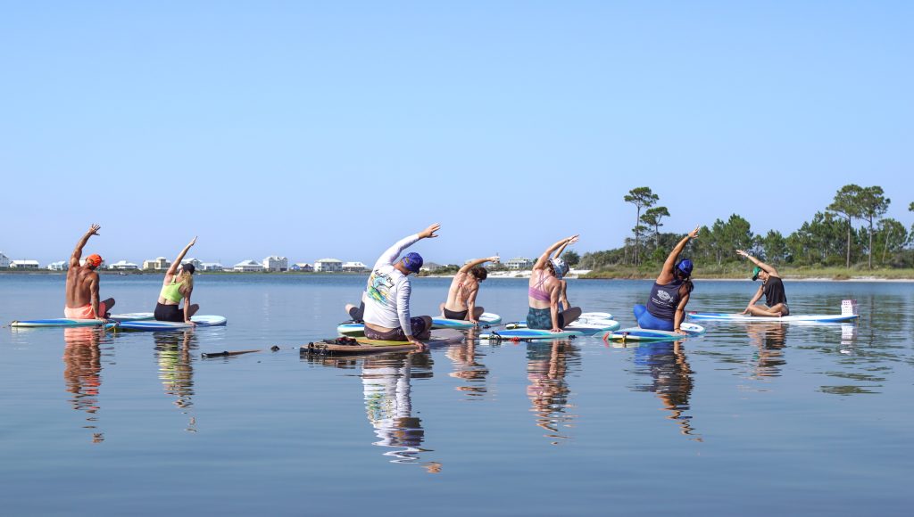group of people on paddleboards doing yoga in Gulf Shores AL