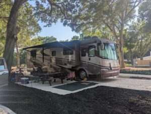 luxury RV parked under shade tree